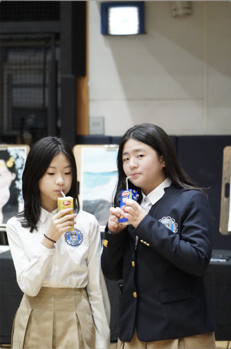 Sixth-graders Ellie An and Alice Kim take a break and enjoy refreshments provided by the PTC. The event not only showcased their artistic talents but also created moments of connection and celebration with friends and faculty. 